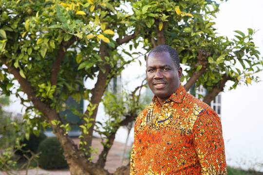 Edwin Muchapondwa standing in front of a green tree