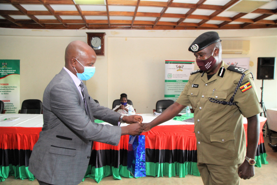 EfD-Mak Centre Director, Assoc. Prof Edward Bbaale presenting a gift to The Assistant Commissioner of Police Simon Peter Okoshi also the Commandant Environmental Police.jpg